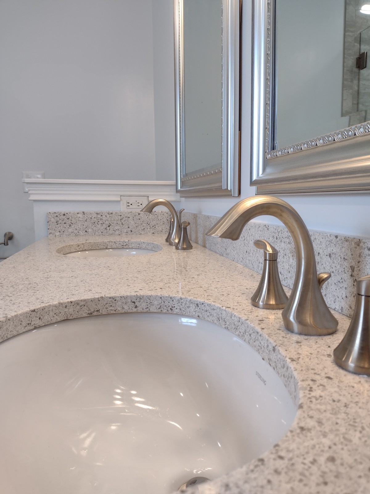 A granite vanity with pewter handles and a faucet